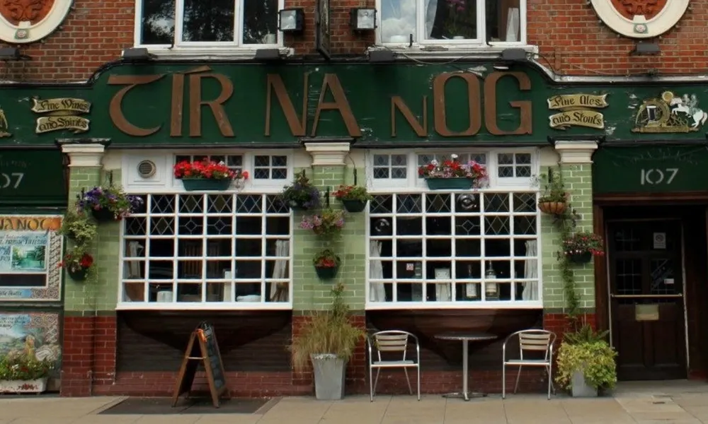 Tir Na Nog on large pub sign with tiled facade