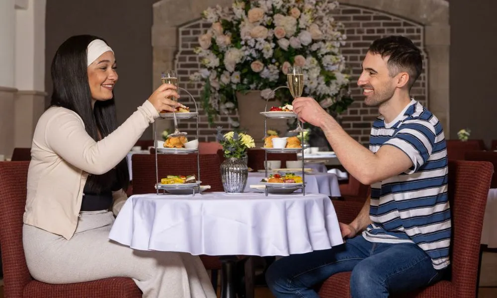 couple enjoying afternoon tea with glasses of prosecco