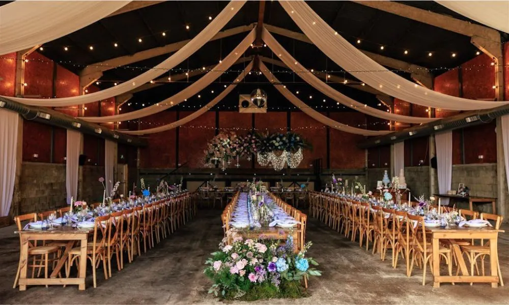 barn with draped awning, banquet tables, and lights