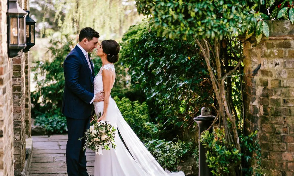 a couple dressed in wedding attire, facing each other
