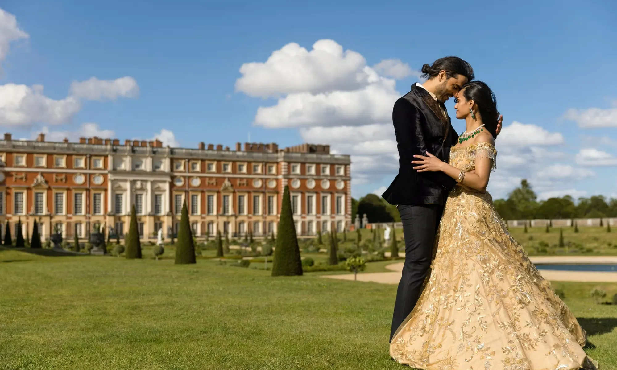 couple standing on lawn at hampton court palace