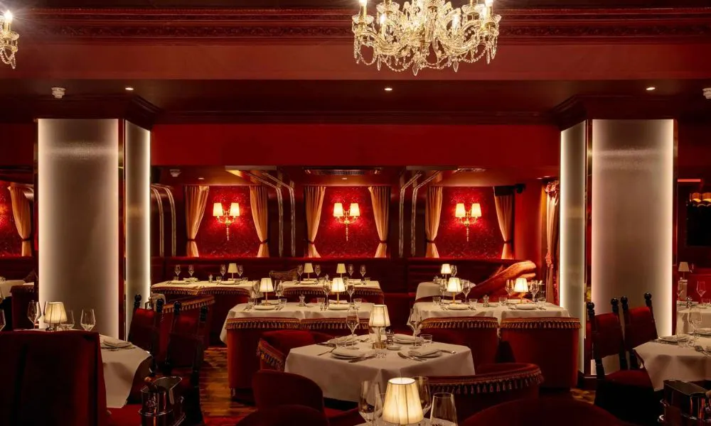 red lounge room with chandelier and plush seating