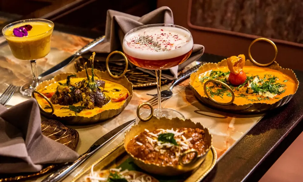 curries laid on a table with cocktails 