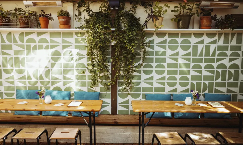 beer garden tables with blue tiled wall and heaters