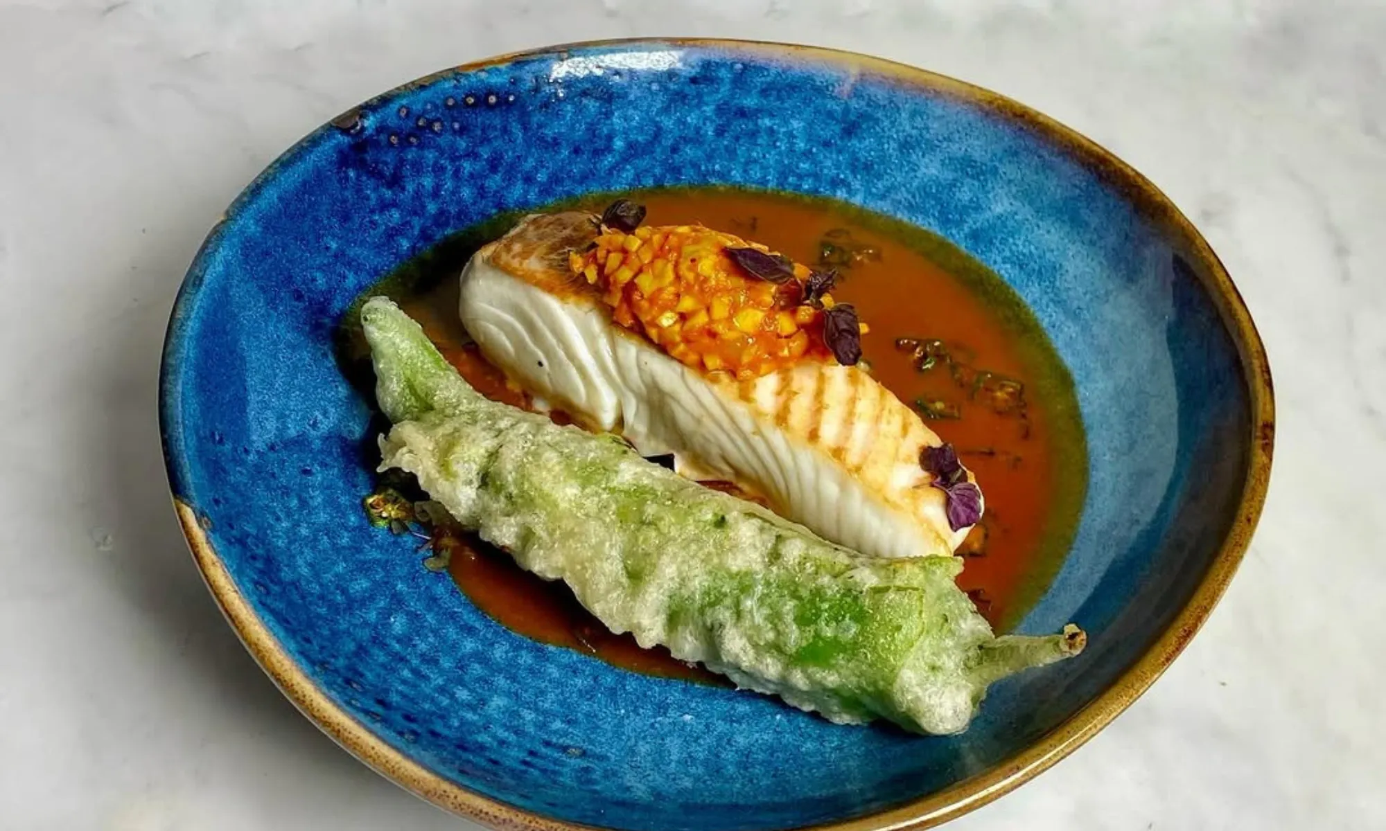 fish dish with a fried and stuffed green chilli