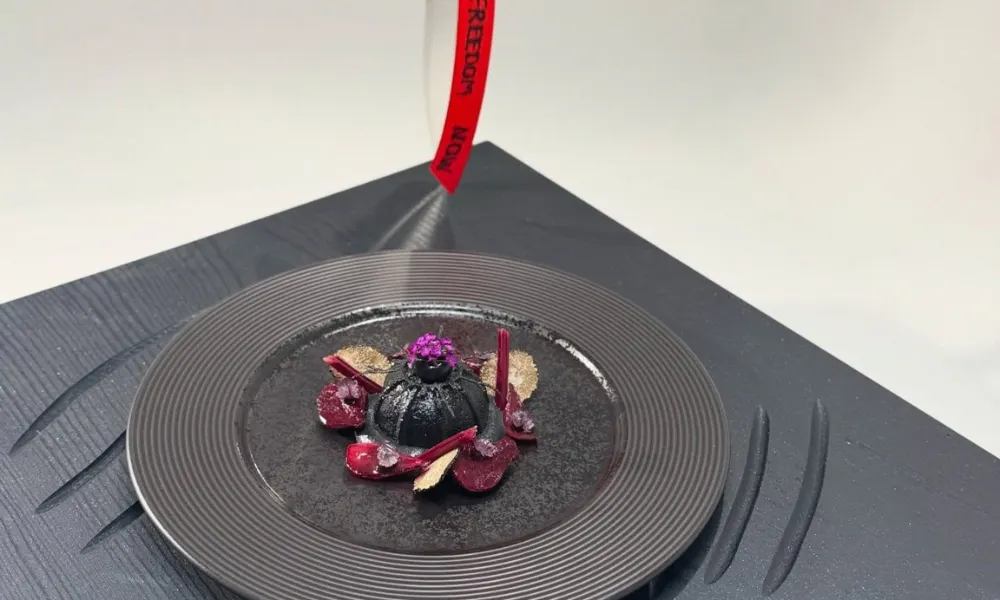 Plate of food with a black dumpling 