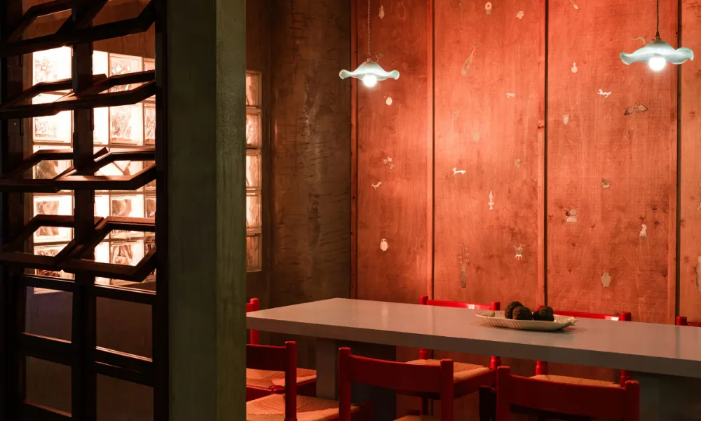 red lit semi private dining space with one table