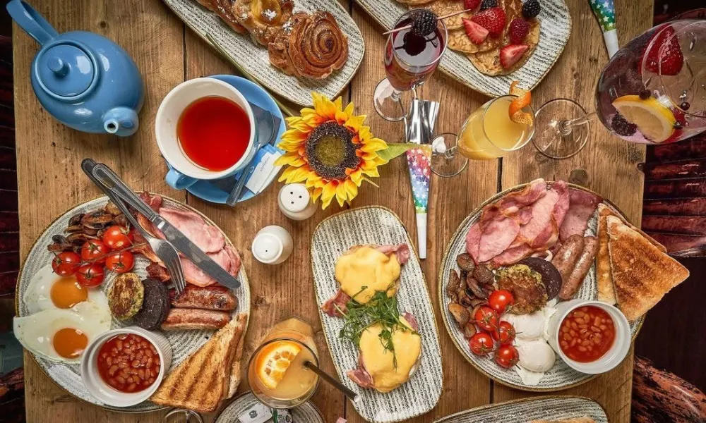 Mimosa and eggs benedict on a table with sunflowers