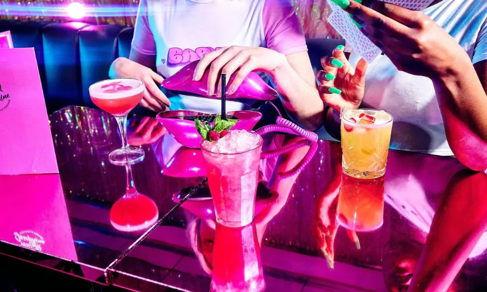 A selection of cocktails in a pink, neon-lit restaurant