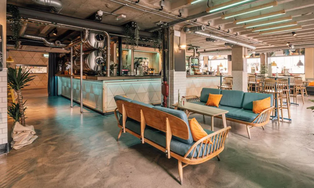 A light dining room with a central bar, lounge seating and industrial decor
