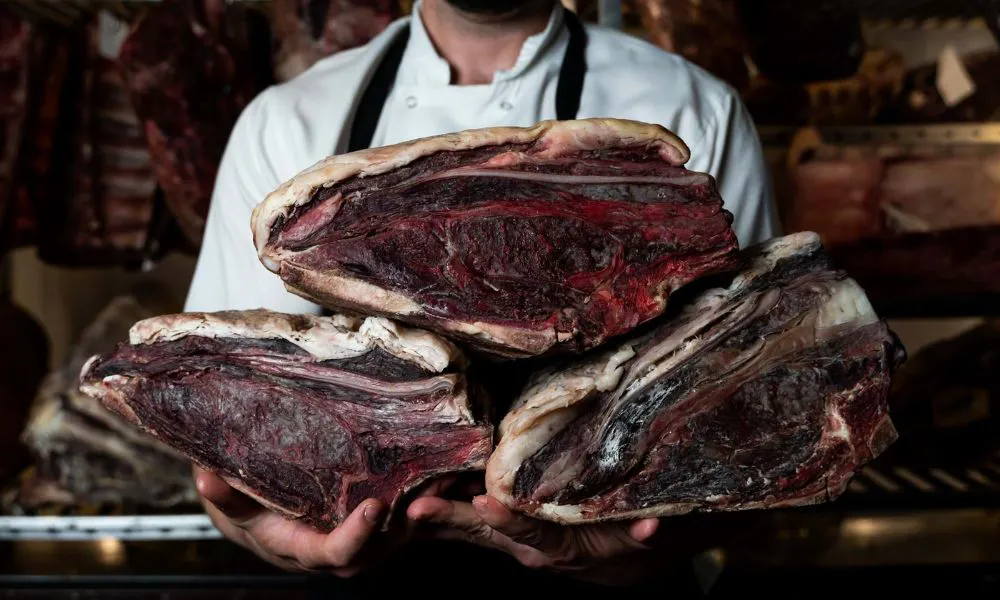 Man holding slabs of dry aged beef