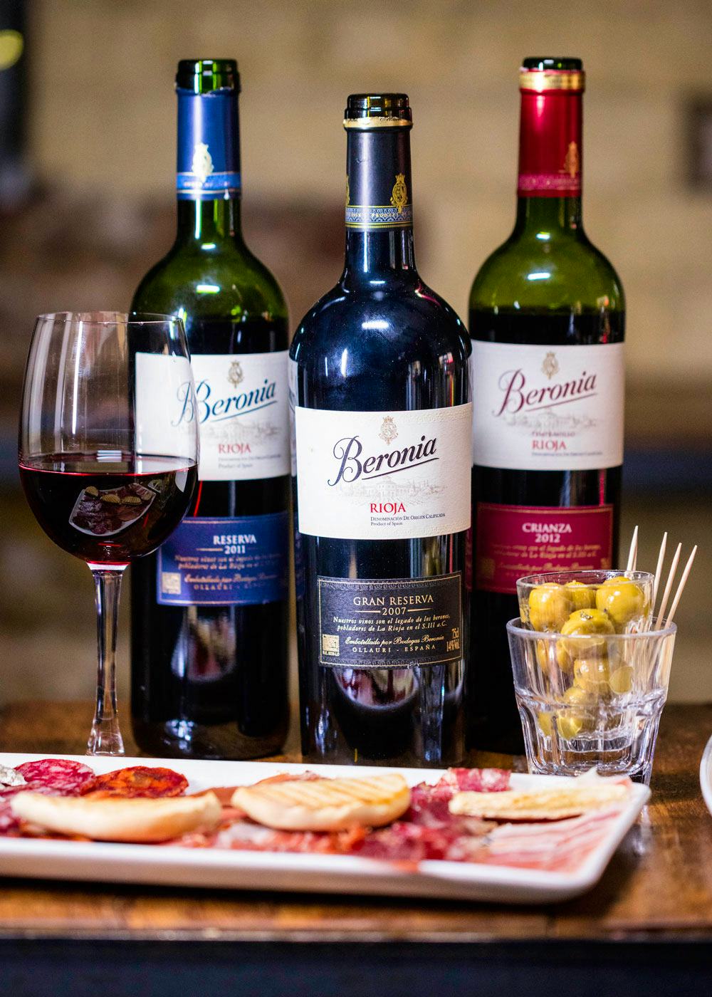 Beronia wine bottles on table with tapas sliced meats