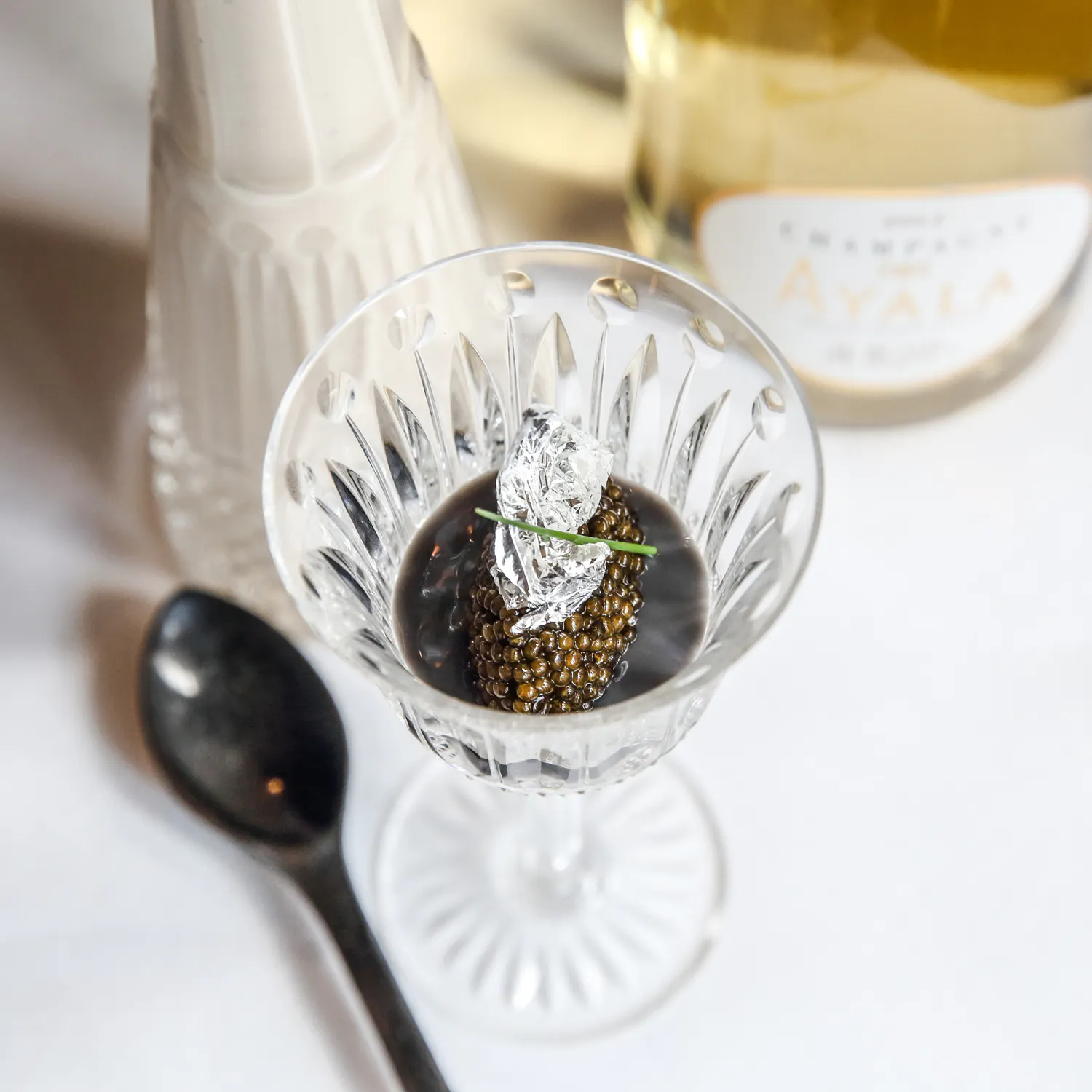 Helene Darroze chef in restaurant with caviar dish and wine